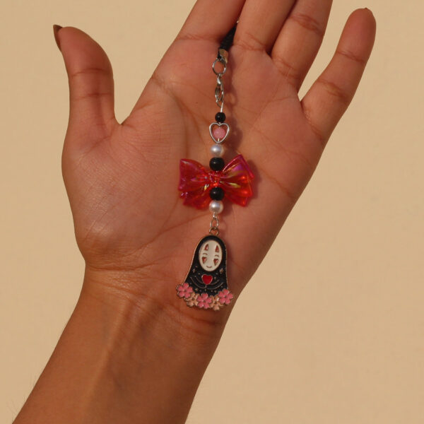 Close-up-of-No-Face-Enamel-Phone-Charm